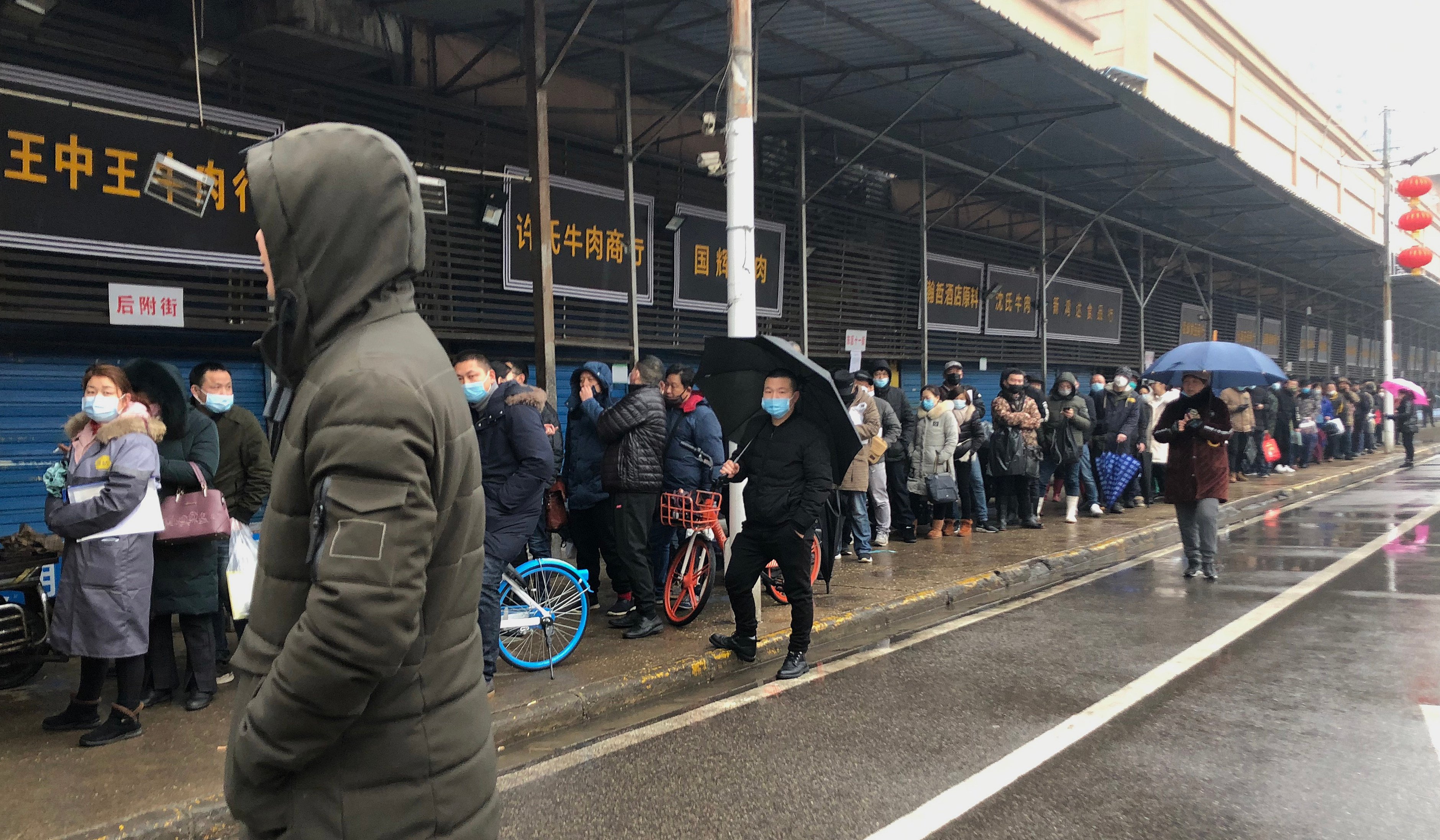 Tenants who ran shops at Wuhan’s Huanan Seafood Market queue up to end their contracts following the market’s closure on January 22, 2020. Photo: Simon Song